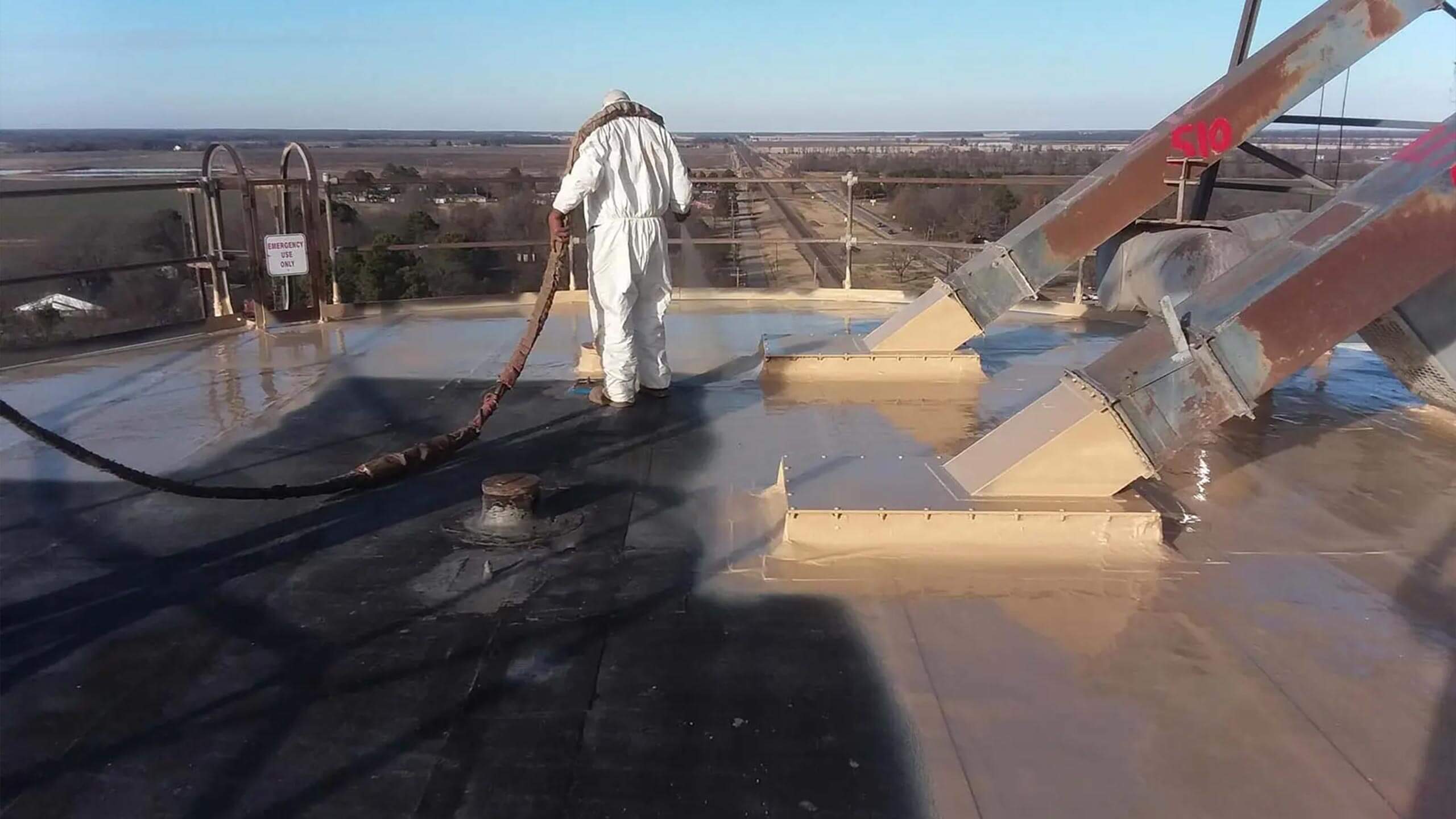 Crew spray-applying Meyer Method polyurea coating on an industrial silo roof in Arkansas